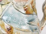 a ceramic pitcher that has a chicken on it