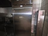 a stainless steel refrigerator in a kitchen with tiled walls