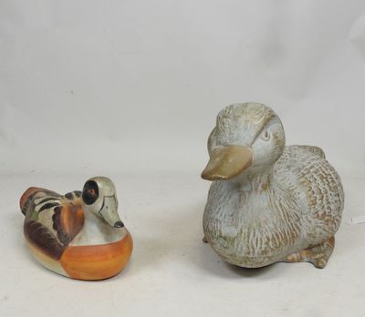 two figurines of ducks sitting next to each other