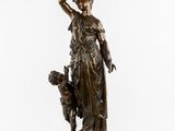 an antique bronze statue of a woman holding a child