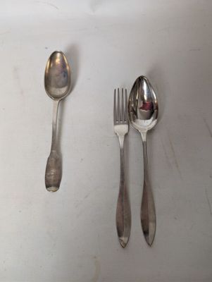 two spoons and a fork sitting on a table