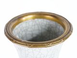 a white vase with a gold rim sitting on a table