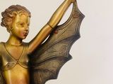 a statue of a little girl with a bat on her arm
