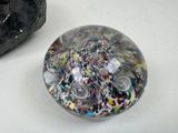 a glass object sitting on a table next to a rock