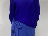 purple and blue dress on a mannequin stand in front of a white wall