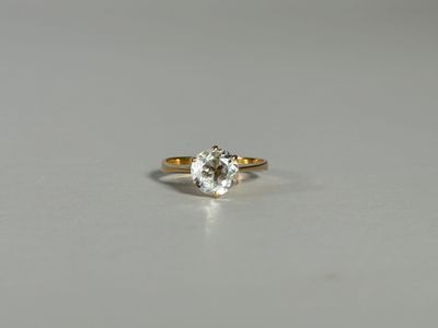 gros plan d'une bague en or avec un diamant blanc