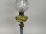 une lampe à huile à l'ancienne surmontée d'un abat-jour en verre
