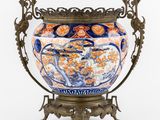 une image représentant un vase posé sur un socle, sur fond blanc