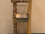 an old wooden chair sitting on top of a white floor next to a wall
