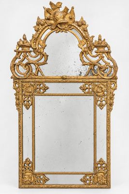 un miroir doré richement décoré, orné d'un motif représentant un oiseau et une fleur