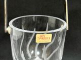 a clear glass bucket with a handle on a black background