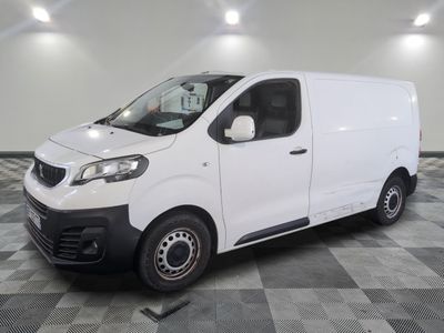 la camionnette blanche est garée sur un sol carrelé en damier