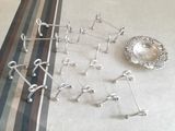 de nombreux objets en argent posés sur une table recouverte d'une nappe rayée