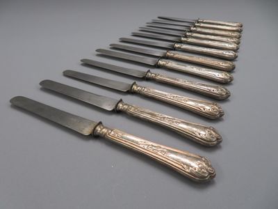 12 couteaux à entremet en métal argenté, riche décor floral,…