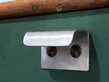 a close up of a green desk with a wooden handle on it