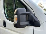 an image of a side view mirror of a white van