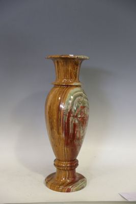 un vase brun posé sur une table à fond blanc