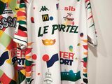 two t - shirts hanging on a rack in a room
