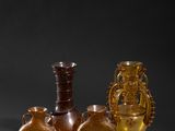 three vases and a vase on a table with a black background