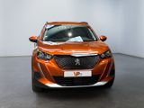 an orange car is parked in a white room with a black floor