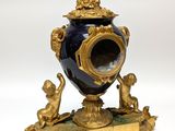 a blue and gold vase with a statue on it