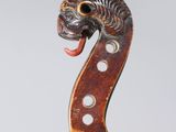 a close up of a violin with a dragon head on it ' s back