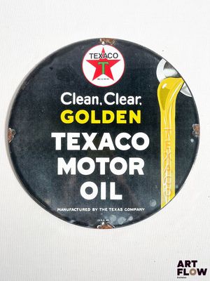 une affiche indiquant « Huile moteur Texaco : propre, limpide, dorée »
