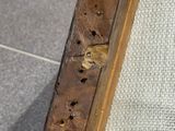 a close up of a piece of wood with holes in it