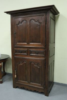 une vieille armoire en bois à deux tiroirs et une petite table