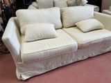 a white couch with pillows on it in a room