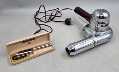un petit objet en argent et une boîte en bois contenant un stylo
