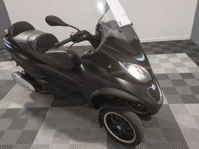un scooter garé sur un sol à damier