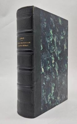 a black book with a green cover sitting on top of a white surface