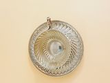 a silver plate with a crystal in it on a yellow surface