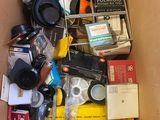 a cardboard box filled with assorted items and a camera