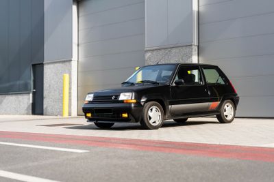 a small black car parked in front of a building
