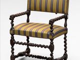 a wooden chair with striped upholstered seat and arms