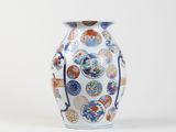 a white vase with a pattern of flowers and birds on it