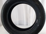 an image of a tire on a white surface with a curtain in the background