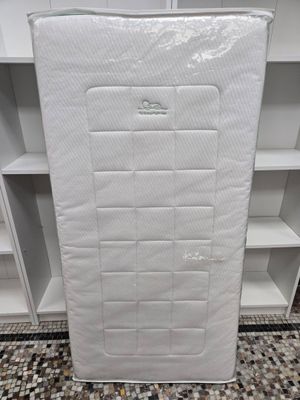 a close up of a mattress in a room with a book shelf