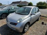 a small silver car parked in a lot next to other cars