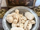 a silver bowl filled with shells on a wooden table