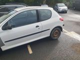 a small white car parked on the side of the road