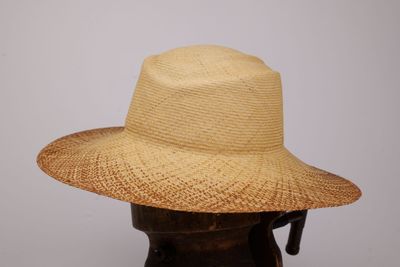 chapeau de paille beige sur une tête de mannequin, sur fond blanc