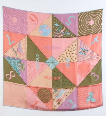 une couette en patchwork rose et verte accrochée au mur