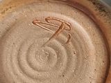a close up of a brown plate with a bird on it