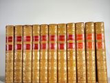 several old books are lined up on a white surface