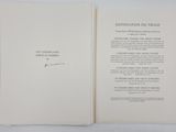 an open book sitting on top of a white table next to a white wall