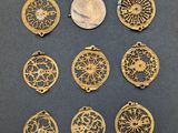 a group of nine brass medallions and a coin on a table