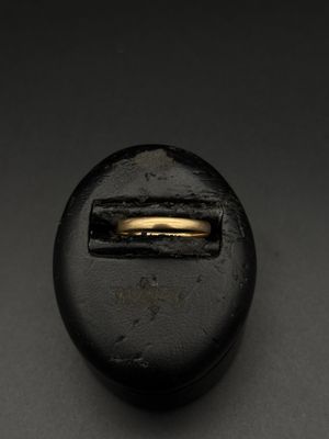 un gros plan d'un bouton noir orné d'un anneau doré